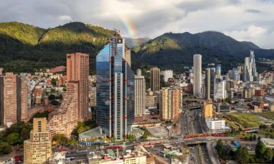 Vista panorámica de Bogotá con los cerros orientales, el centro financiero y un arcoíris sobre la ciudad durante la celebración de su aniversario.