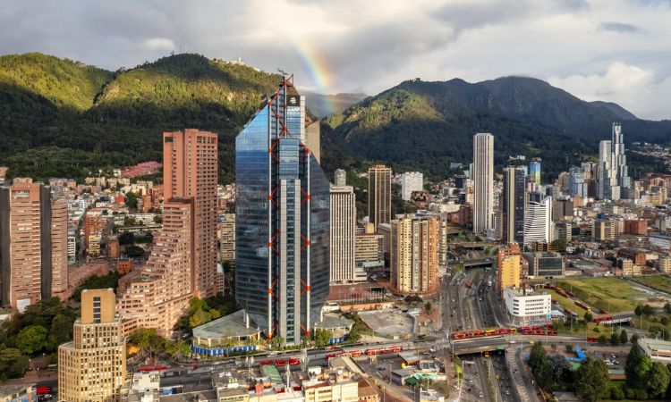 Vista panorámica de Bogotá con los cerros orientales, el centro financiero y un arcoíris sobre la ciudad durante la celebración de su aniversario.